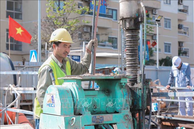 Công nhân bơm hỗn hợp gia cố nền đất tại giếng khoan gói thầu 49, xây dựng tuyến cống bao sông Lừ thuộc dự án xử lý nước thải TP Hà Nội. (Ảnh: Phan Phương /TTXVN)